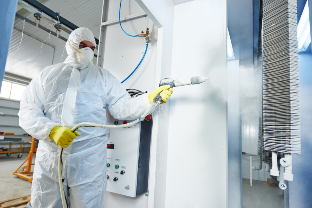 Trabajadores industriales aplicando pintura y respetando normas de seguridad de pintura industrial
