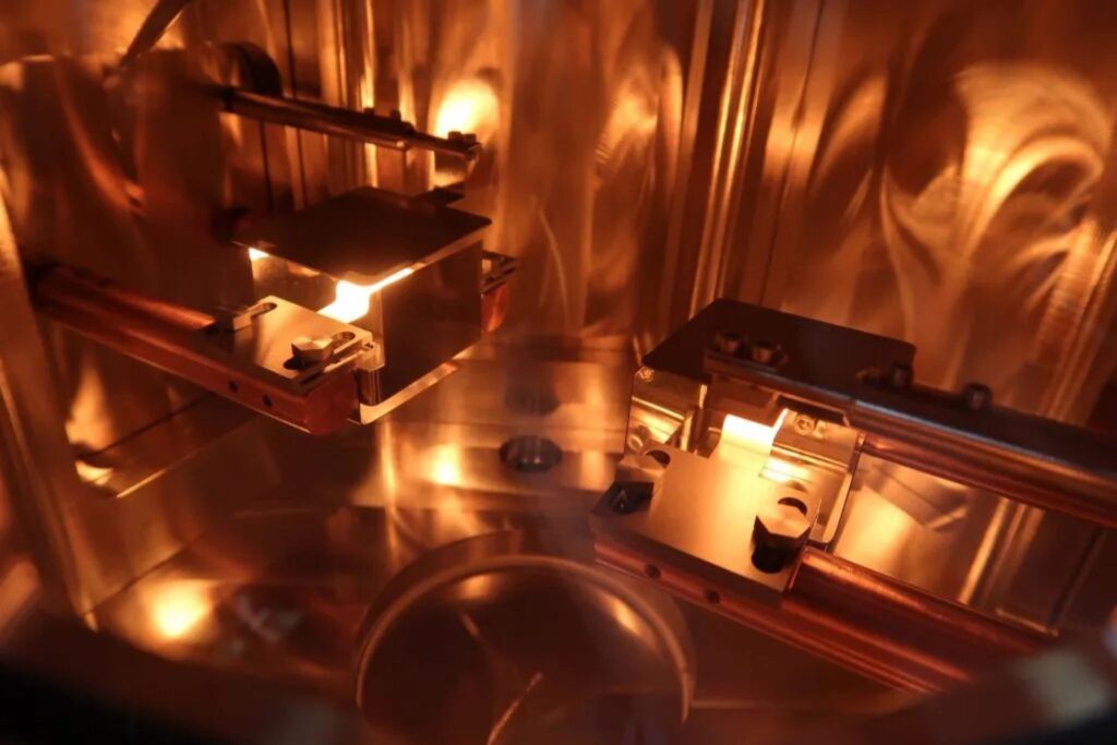 Industrial vacuum chamber during the PVD (Physical Vapor Deposition) process for thin film coating deposition.