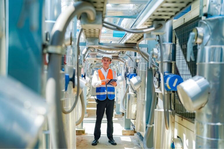 Un trabajador de una fábrica evaluando qué factores afectan la durabilidad de los recubrimientos industriales, en su planta.