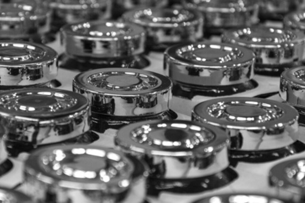 Piezas metálicas con acabado brillante tras proceso de recubrimiento al vacío para mejorar resistencia y apariencia superficial.